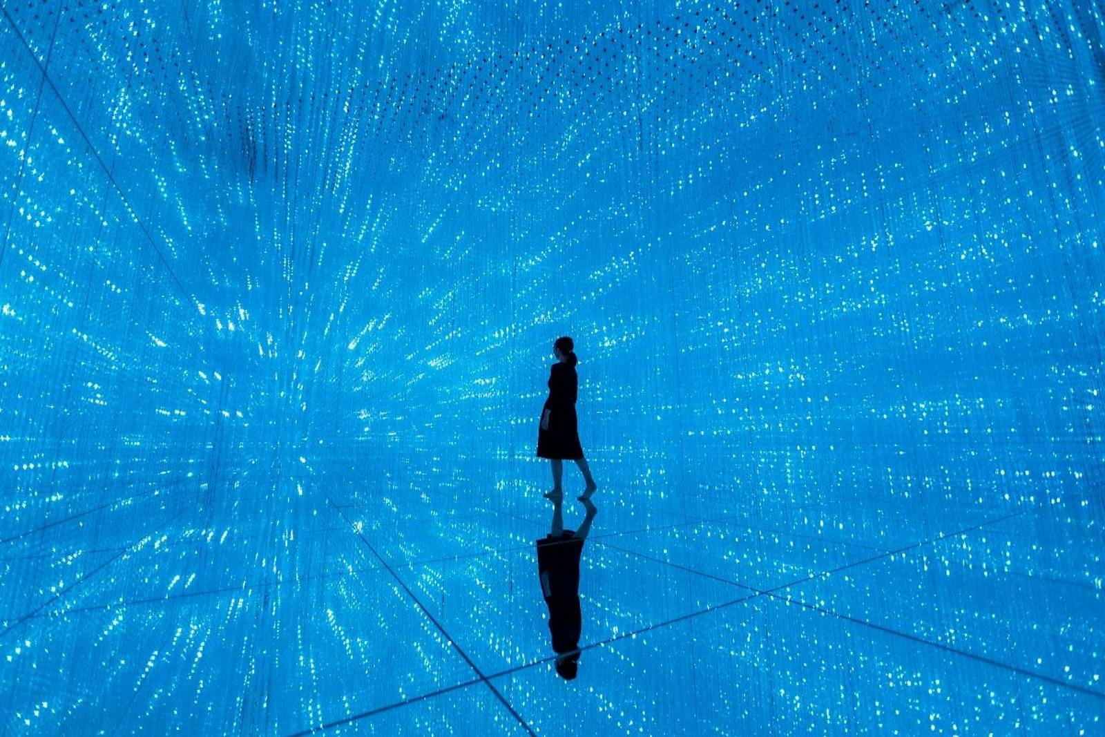 Silhouette solitaire dans l'immensité bleue de teamLab Planets