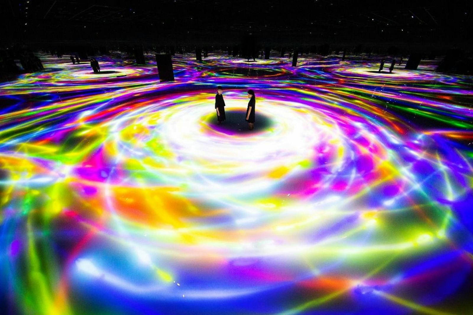 Două siluete în imersiunea luminoasă a teamLab Planets