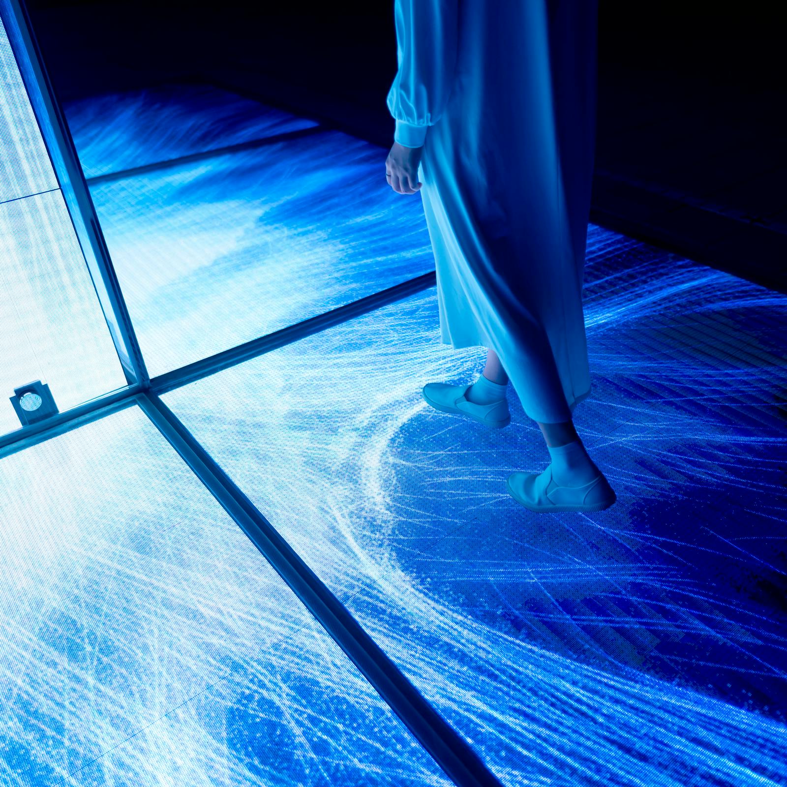 在teamLab Planets发光地面上行走的人